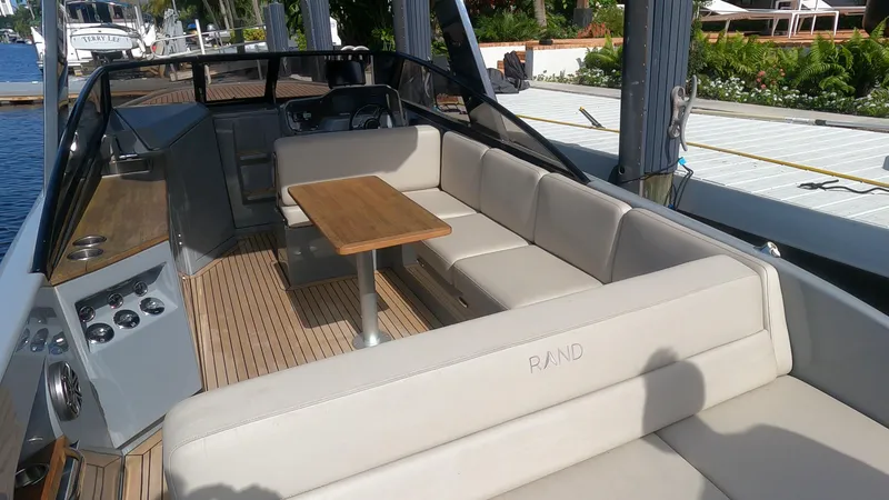 Slide: The Image of 2021 Rand Leisure boat with spacious seating and wooden table, docked by the water. - 33