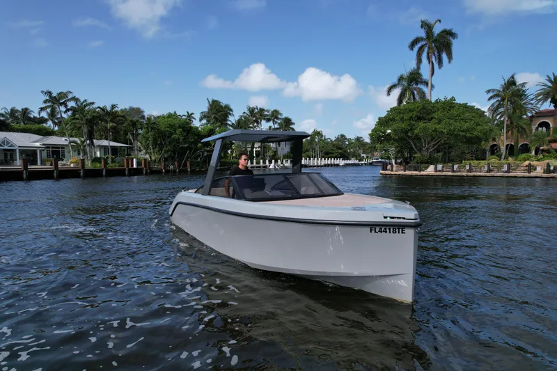 Slide: The Image of 2021 Rand Leisure boat cruising on a scenic waterway with palm trees and houses. - 4