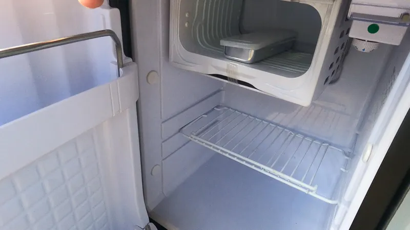 Slide: The Image of Empty Rand Leisure refrigerator interior, 2021 model, with open door and visible shelves. - 40