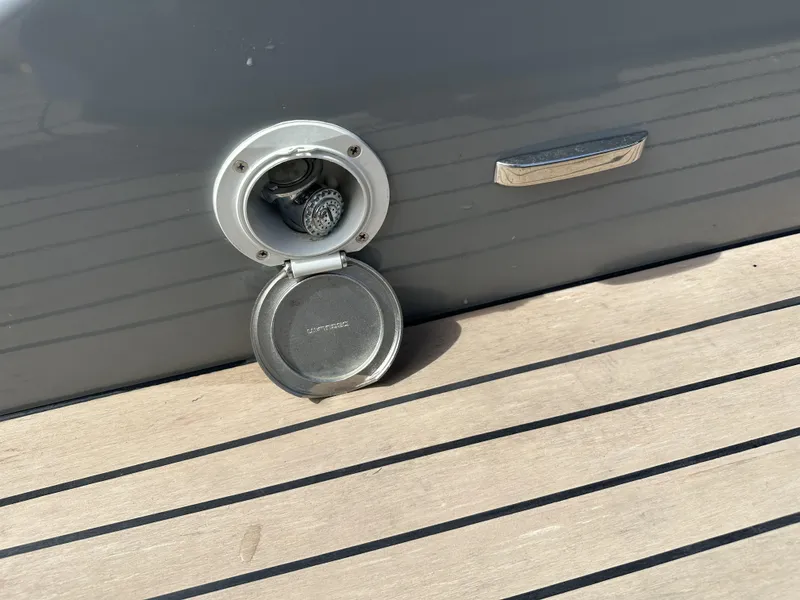 Slide: The Image of Fuel cap on a 2021 Rand Leisure boat, open on a wooden deck. - 43