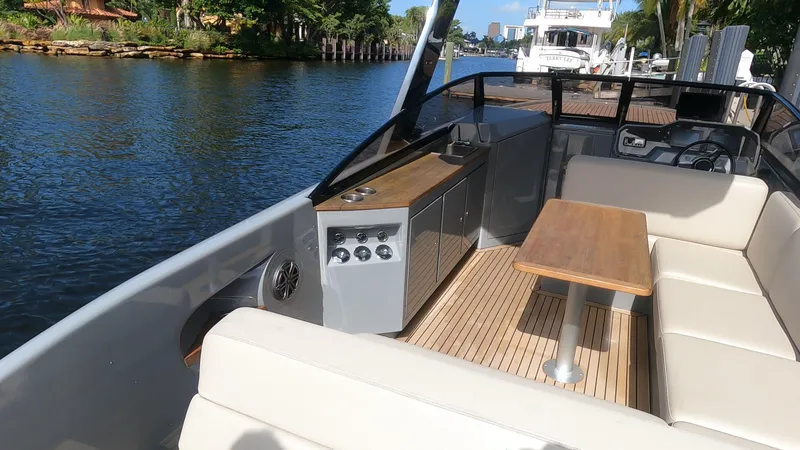 Slide: The Image of 2021 Rand Leisure boat interior with seating and table on a sunny day. - 48