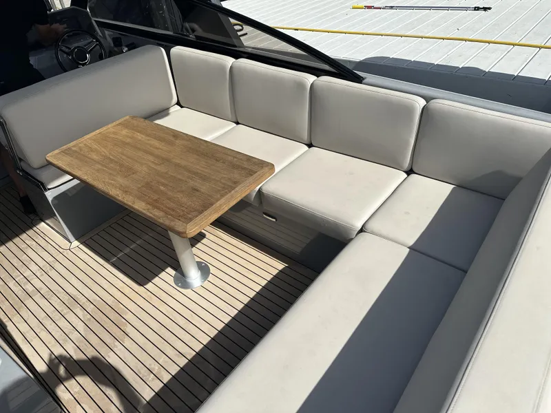 Slide: The Image of Luxurious seating area on 2021 Rand Leisure boat with wooden table and cushioned seats. - 9