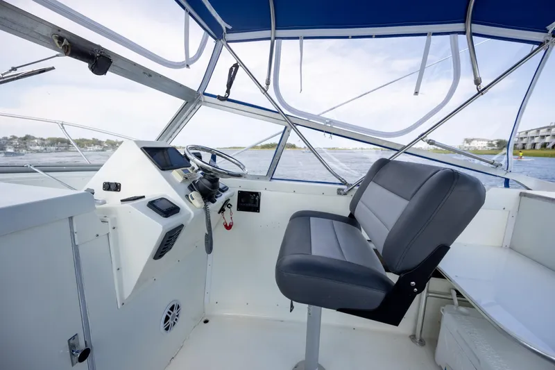 Slide: The Image of Interior of 1983 Bertram 28 Moppie boat with steering wheel and seating. - 13