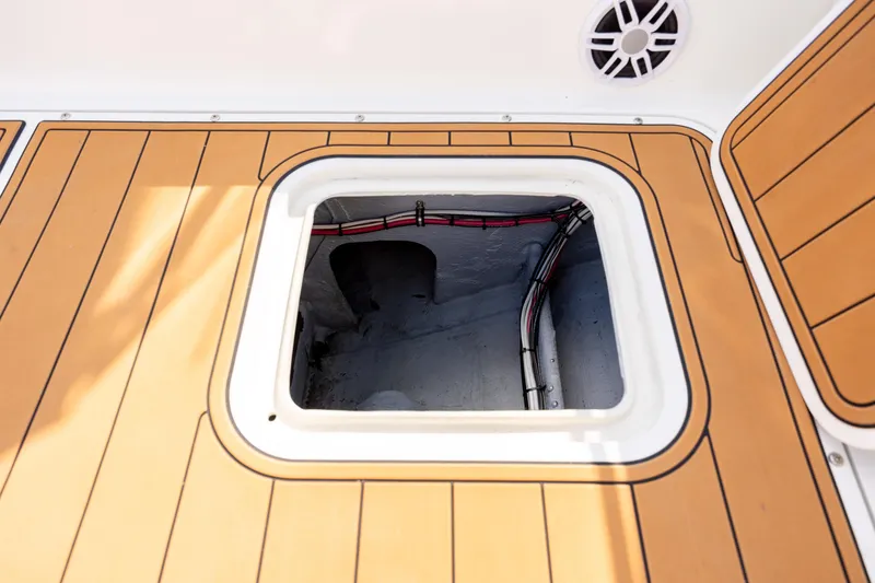 Slide: The Image of 1983 Bertram 28 Moppie boat hatch with teak flooring and visible wiring. - 18