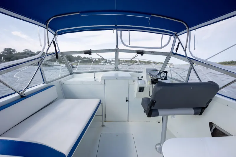 Slide: The Image of Interior of 1983 Bertram 28 Moppie boat with blue canopy and seating. - 8