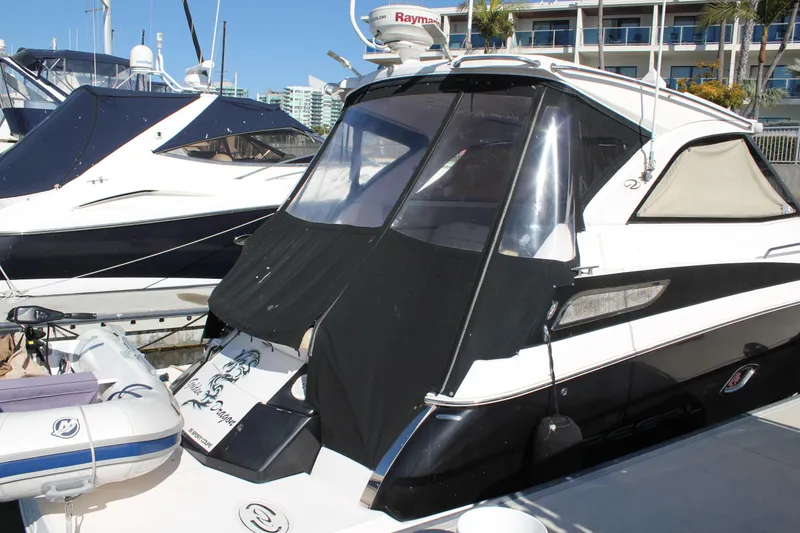Slide: The Image of 2012 Regal 35 Sport Coupe yacht docked at marina, featuring sleek black and white design. - 17
