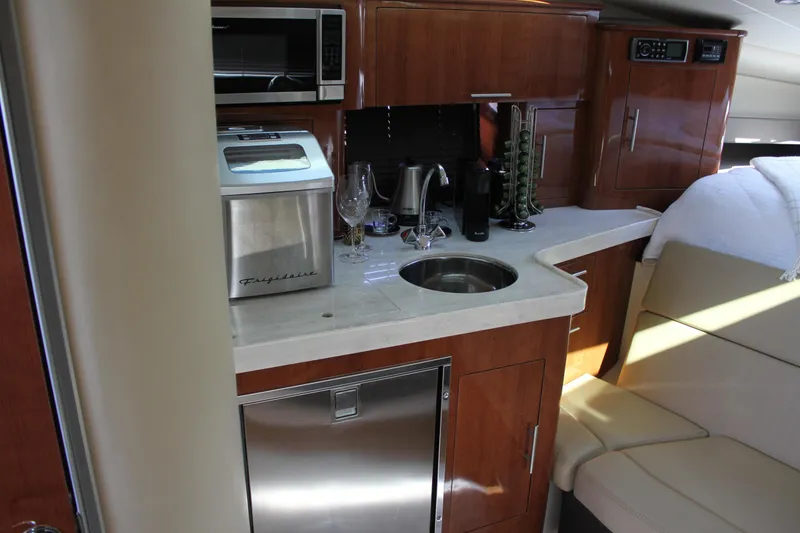 Slide: The Image of 2012 Regal 35 Sport Coupe interior with kitchenette, featuring sink, microwave, and seating area. - 28