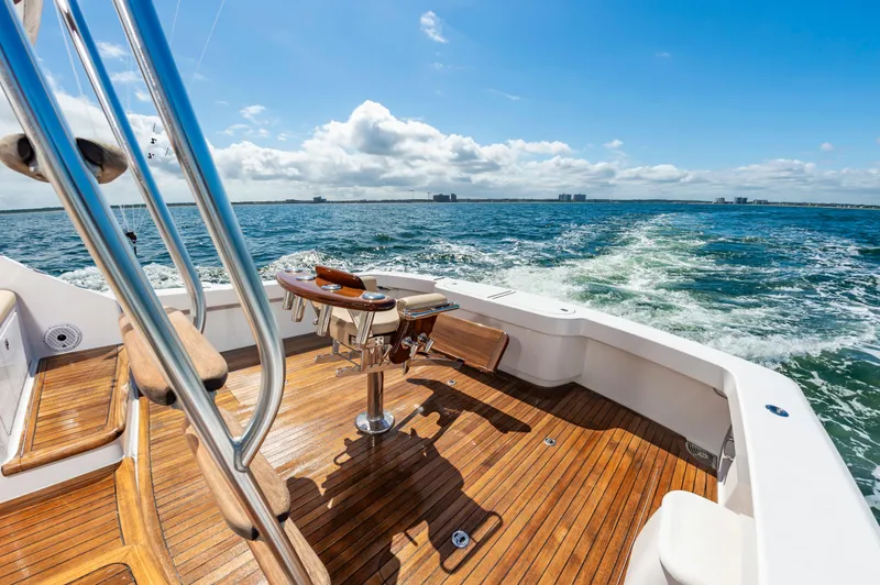 Slide: The Image of 2023 Viking 46 yacht with wooden deck cruising on open sea under blue sky. - 18