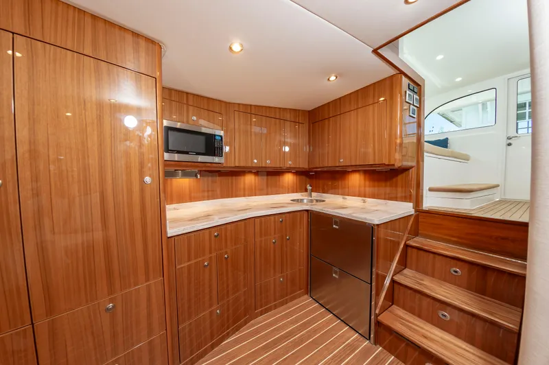 Slide: The Image of Luxurious 2023 Viking 46 yacht interior kitchen with wood cabinetry and modern appliances. - 44