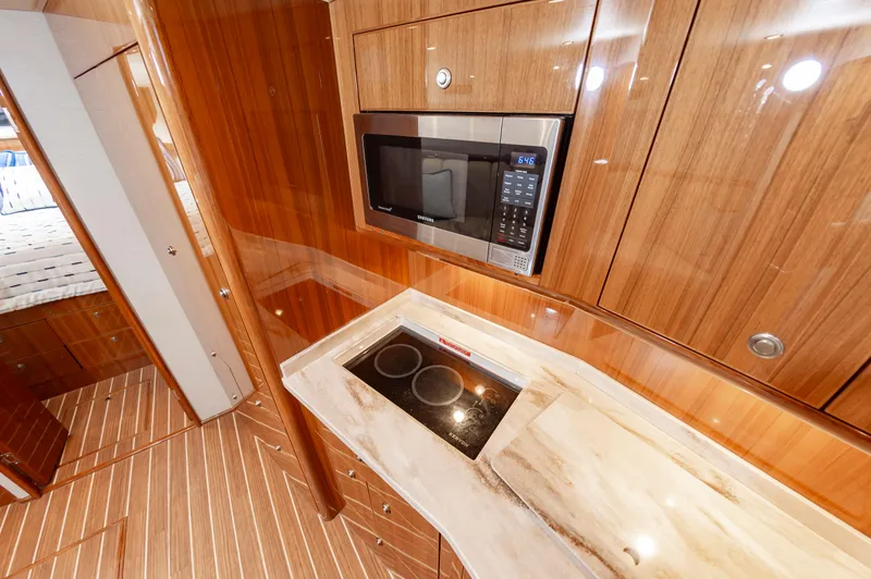Slide: The Image of Luxurious 2023 Viking 46 yacht kitchen with modern appliances and wood cabinetry. - 48
