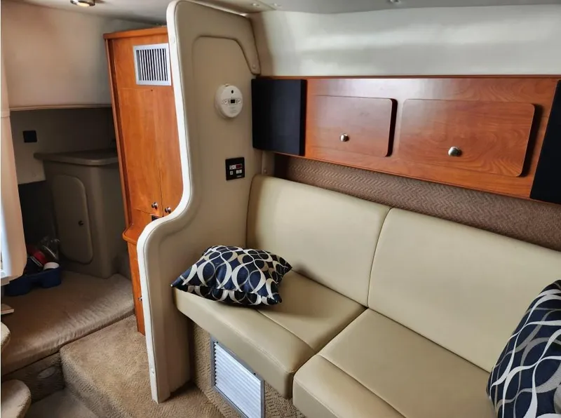 Slide: The Image of Interior of 2007 Rinker 300 Express Cruiser with beige seating and wooden cabinets. - 11