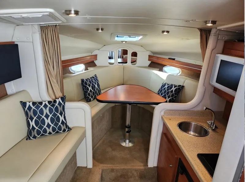 Slide: The Image of Interior of 2007 Rinker 300 Express Cruiser with seating, table, and kitchenette. - 13
