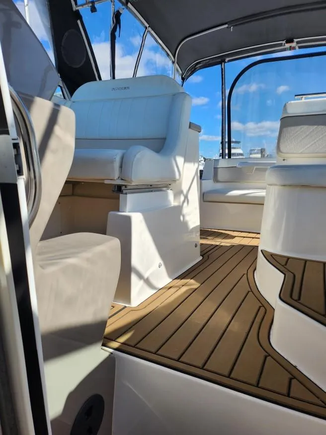 Slide: The Image of 2007 Rinker 300 Express Cruiser interior with seating and wood flooring. - 4