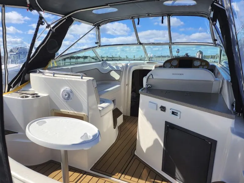 Slide: The Image of 2007 Rinker 300 Express Cruiser interior with seating and helm, under a clear blue sky. - 6