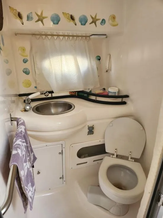 Slide: The Image of 2007 Rinker 300 Express Cruiser bathroom with sink, toilet, and nautical decor. - 9