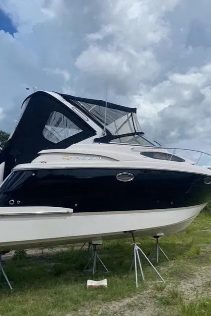 Slide: The Image of 2006 Regal 2860 Window Express boat on stands under cloudy sky. - 1