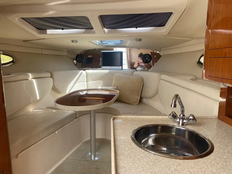 Slide: The Image of Interior of 2006 Regal 2860 Window Express boat with seating, table, and sink. - 12