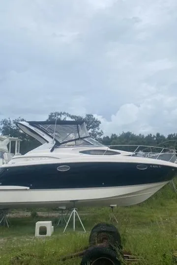 Slide: The Image of 2006 Regal 2860 Window Express boat on land under cloudy sky. - 5