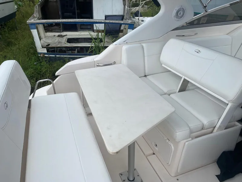 Slide: The Image of 2006 Regal 2860 Window Express boat interior with white seating and table. - 8