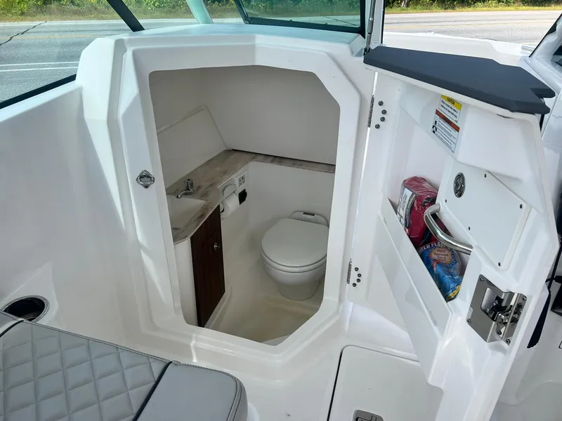 Slide: The Image of 2022 Pursuit DC 266 Dual Console boat interior with compact bathroom. - 18