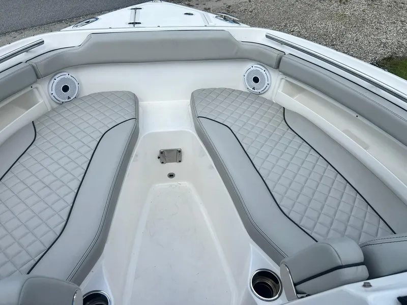 Slide: The Image of 2022 Pursuit DC 266 Dual Console boat interior with cushioned seating and speakers. - 29