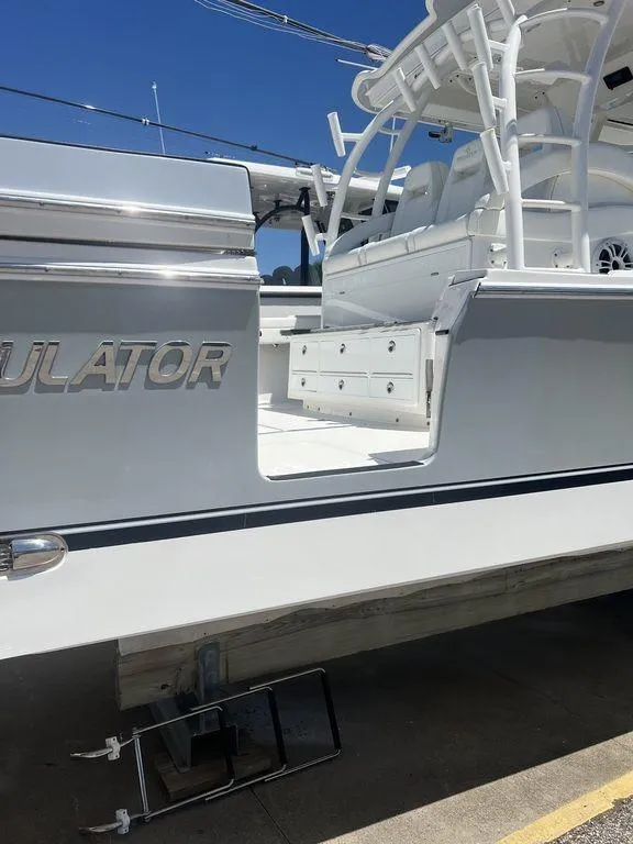 Slide: The Image of 2021 Regulator 41 boat, sleek design, white exterior, docked under clear blue sky. - 13