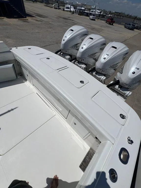 Slide: The Image of 2021 Regulator 41 boat with four powerful outboard engines, docked at a marina. - 20