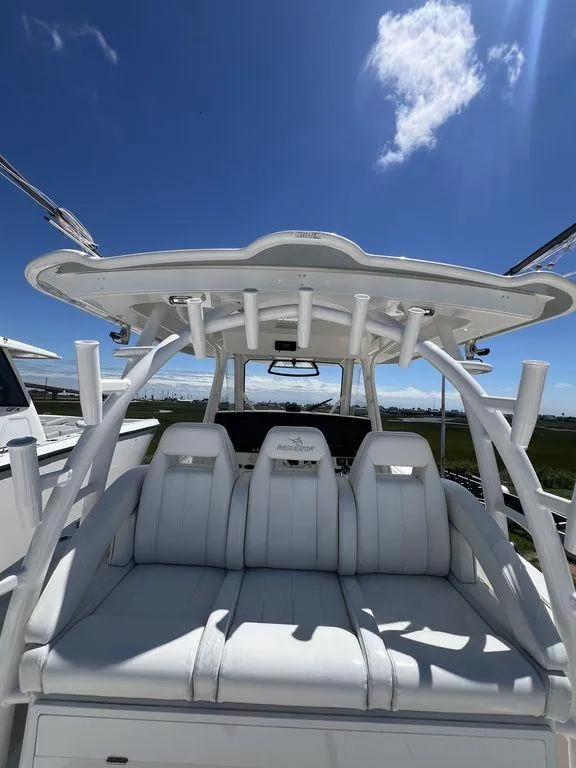 Slide: The Image of 2021 Regulator 41 boat with white seating and rod holders under a clear blue sky. - 23