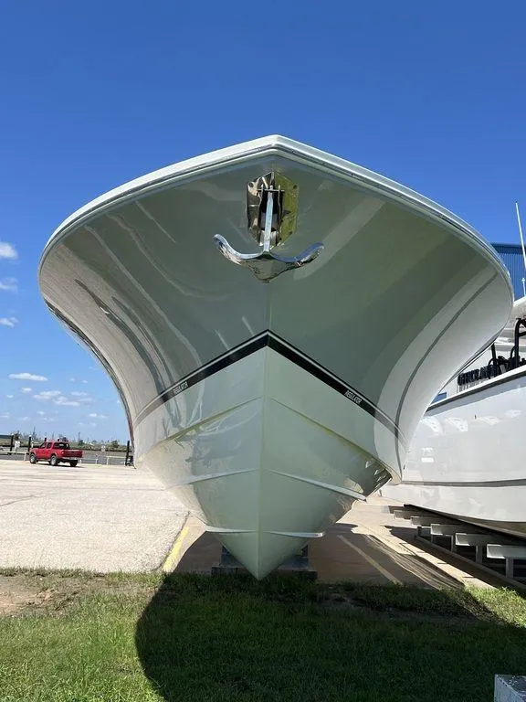 Slide: The Image of 2021 Regulator 41 boat, sleek design, parked on grass under clear blue sky. - 4