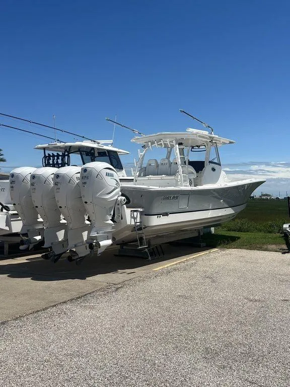 Slide: The Image of 2021 Regulator 41 boat with triple outboard engines on display under clear blue sky. - 5
