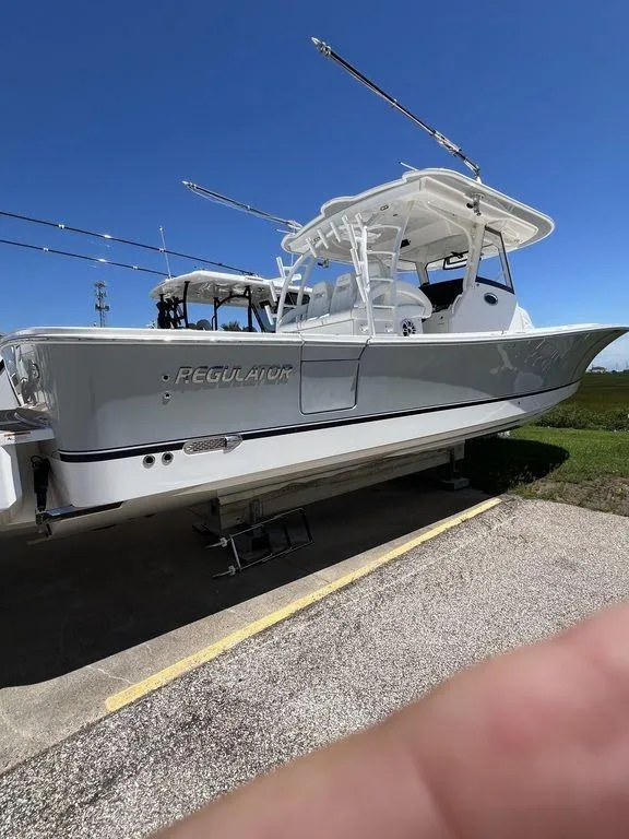 Slide: The Image of 2021 Regulator 41 boat with sleek design, docked under clear blue sky. - 6