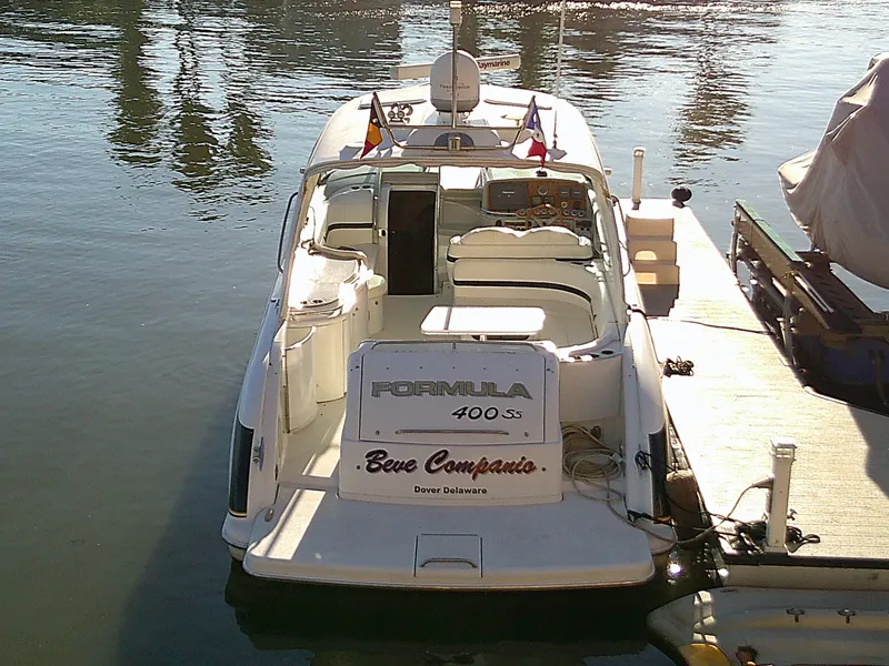 Slide: The Image of 2007 Formula 400ss boat docked, rear view, sunny day, flags displayed. - 2