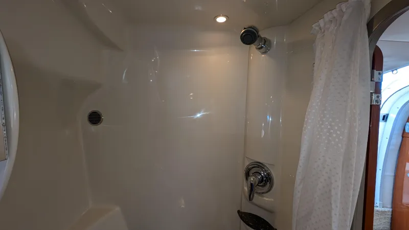 Slide: The Image of 2007 Formula 400ss boat shower interior with white curtain and modern fixtures. - 30