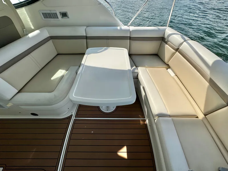 Slide: The Image of Luxurious seating area on 2013 Sea Ray 410 Sundancer yacht with elegant table and wood flooring. - 11