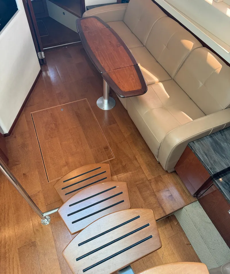 Slide: The Image of Interior of 2013 Sea Ray 410 Sundancer with wooden flooring and beige sofa. - 17