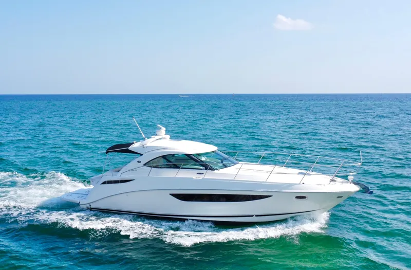 Slide: The Image of 2013 Sea Ray 410 Sundancer cruising on open blue sea. - 2
