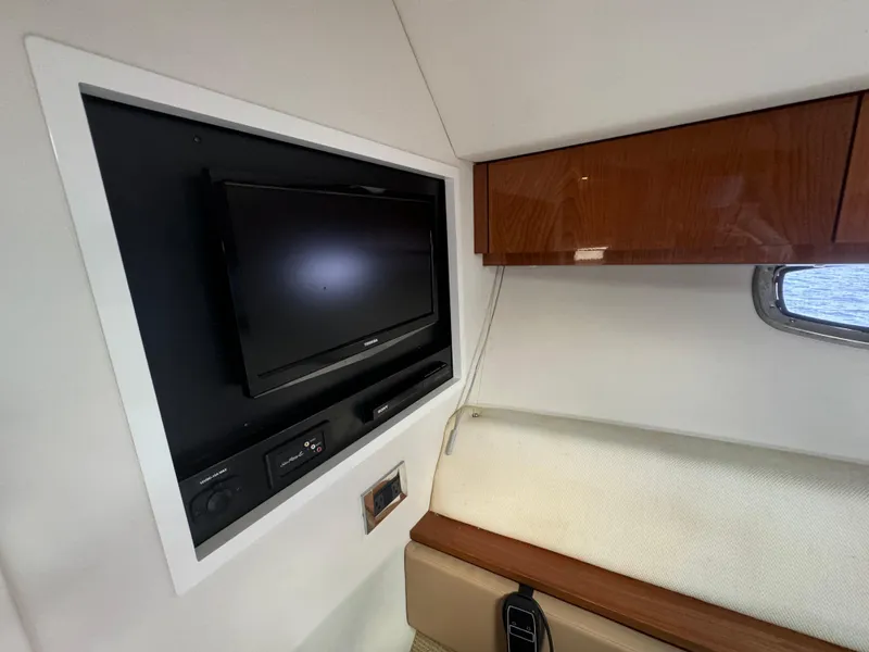Slide: The Image of Interior of 2013 Sea Ray 410 Sundancer with TV and wooden cabinet. - 28
