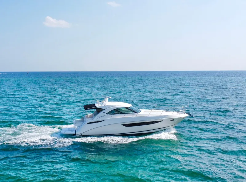 Slide: The Image of 2013 Sea Ray 410 Sundancer cruising on open blue ocean. - 3