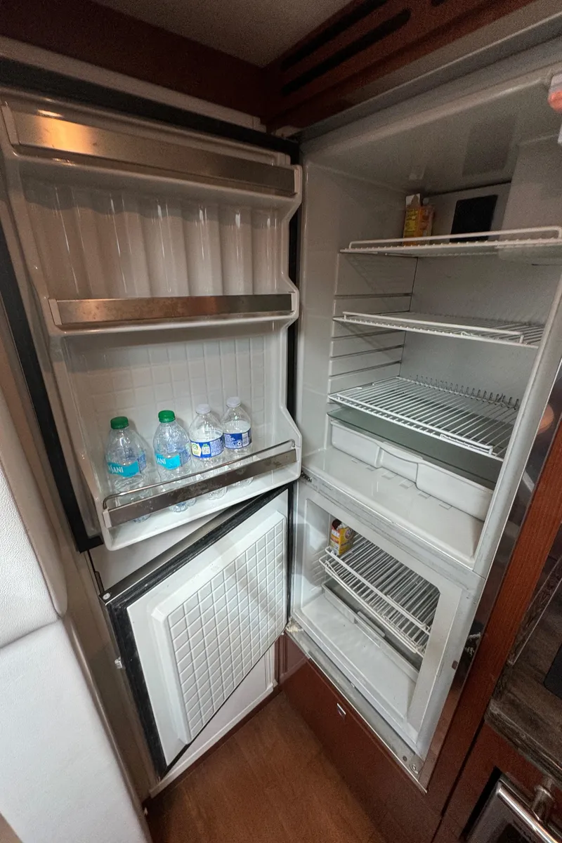 Slide: The Image of Open refrigerator inside 2013 Sea Ray 410 Sundancer yacht, stocked with drinks and essentials. - 31