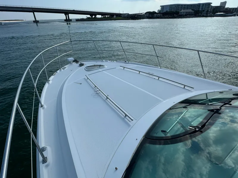 Slide: The Image of Sea Ray 410 Sundancer 2013 yacht on water near a bridge and cityscape. - 32