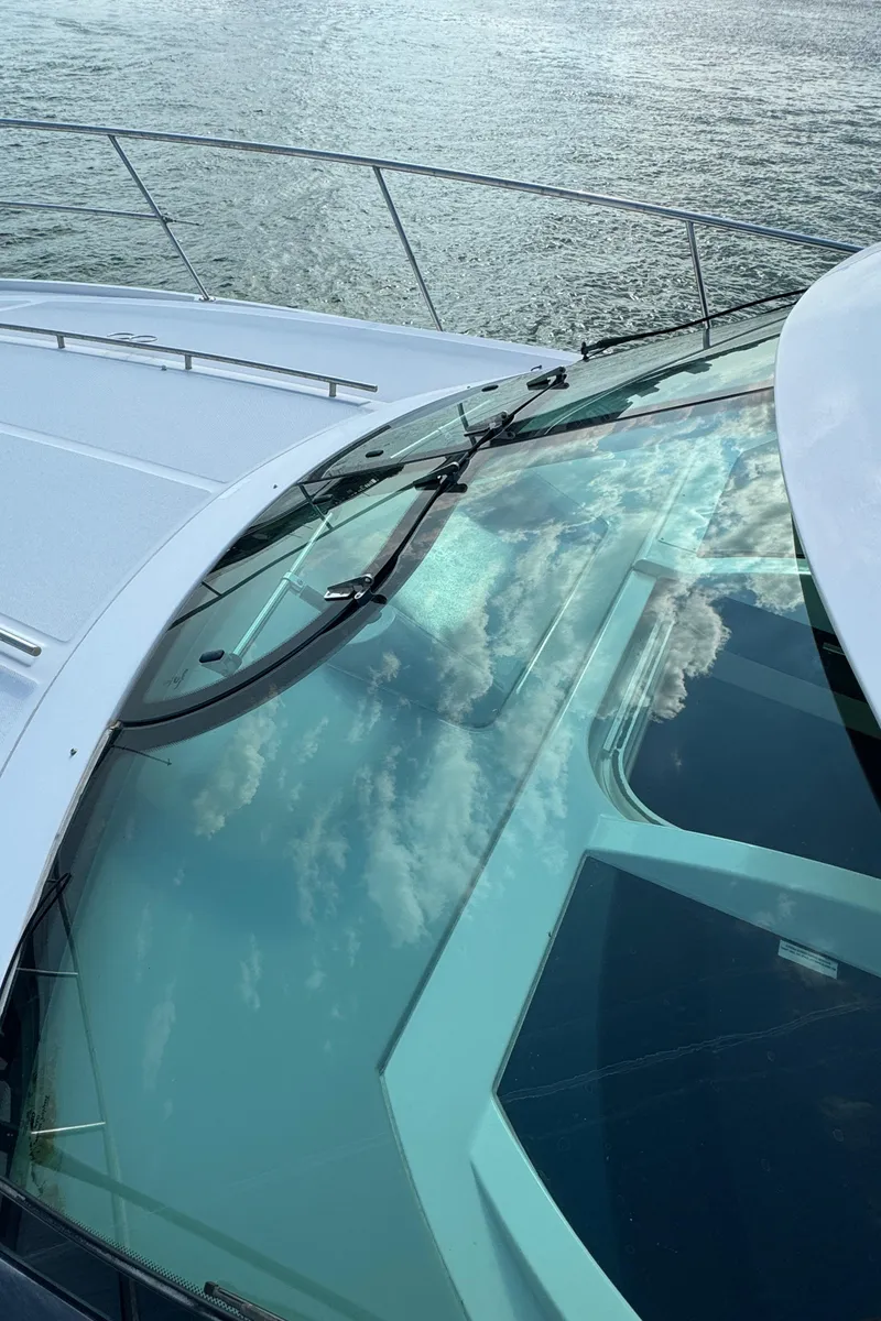 Slide: The Image of 2013 Sea Ray 410 Sundancer yacht with reflective glass on calm water. - 34