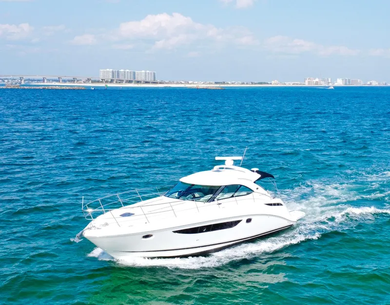 Slide: The Image of 2013 Sea Ray 410 Sundancer cruising on blue ocean waters under a clear sky. - 6