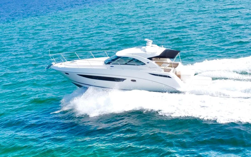 Slide: The Image of 2013 Sea Ray 410 Sundancer cruising on clear blue ocean waters. - 8