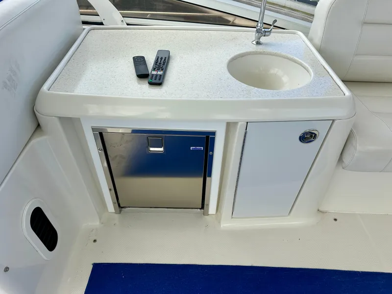 Slide: The Image of 2008 Carver 43 Super Sport yacht interior with sink, mini fridge, and remote controls. - 10