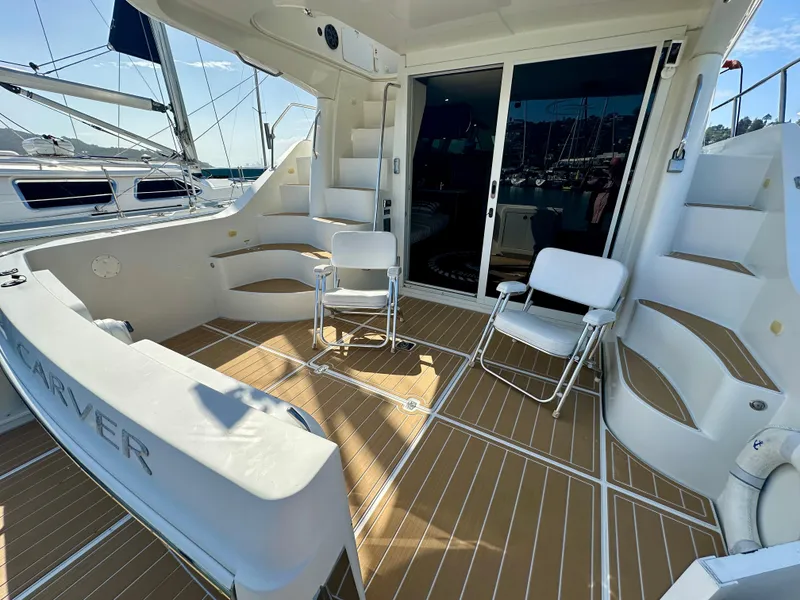 Slide: The Image of 2008 Carver 43 Super Sport yacht deck with seating and stairs, docked at marina. - 16