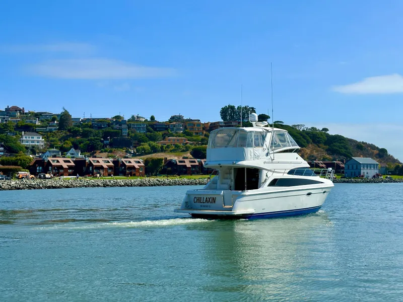 Slide: The Image of 2008 Carver 43 Super Sport yacht cruising near scenic waterfront homes. - 4