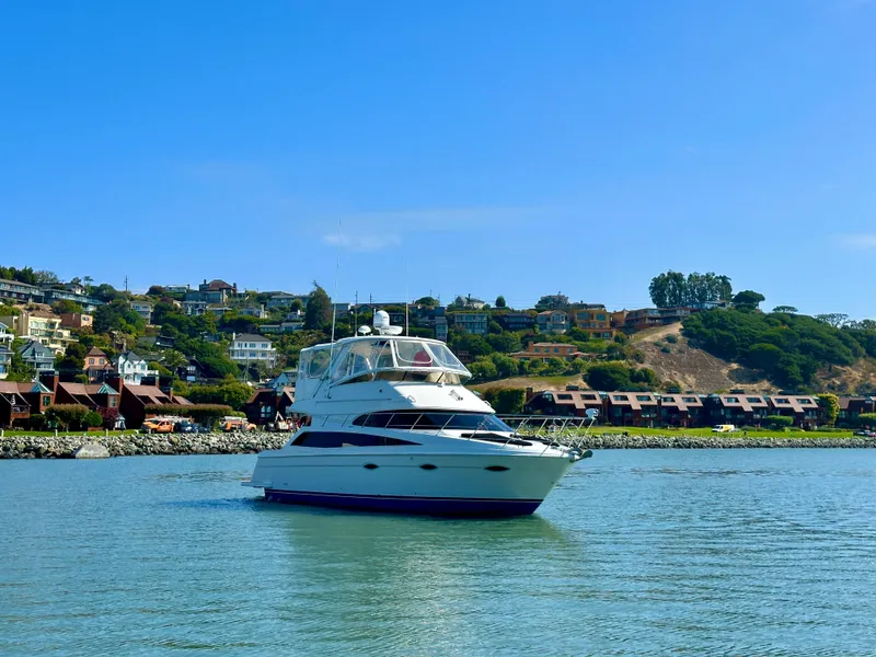 Slide: The Image of 2008 Carver 43 Super Sport yacht on calm water with scenic hillside background. - 5