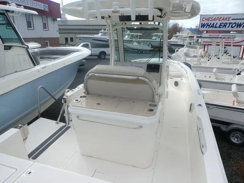 Slide: The Image of 2024 Boston Whaler 280 Dauntless boat at dealership, showcasing spacious deck and seating. - 10