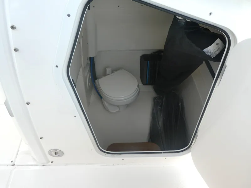 Slide: The Image of 2024 Boston Whaler 280 Dauntless boat interior with compact marine toilet. - 13
