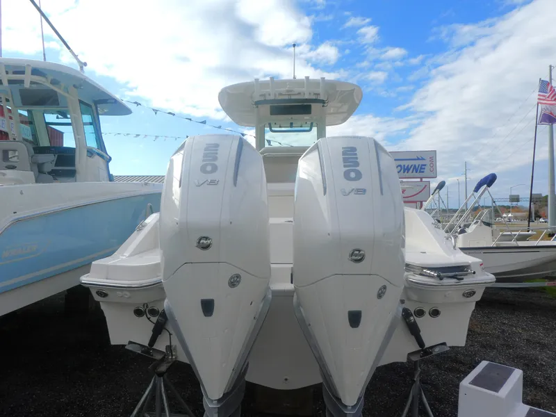 Slide: The Image of 2024 Boston Whaler 280 Dauntless with twin 250 V8 engines, docked under a blue sky. - 2